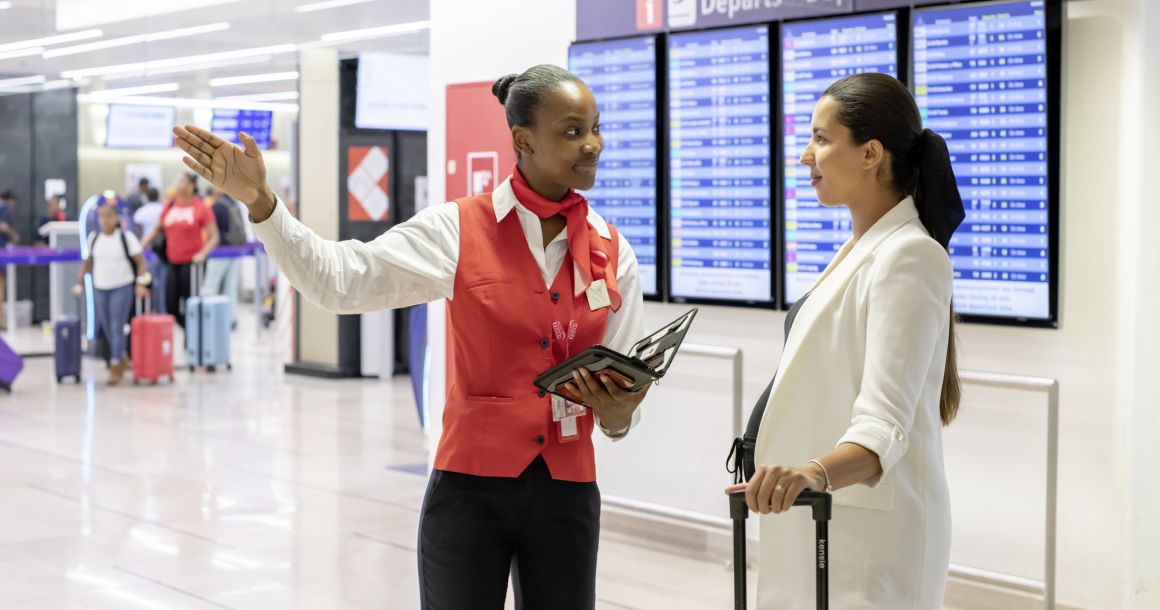 Une salarié de GSF renseigne une touriste dans un aéroport. 