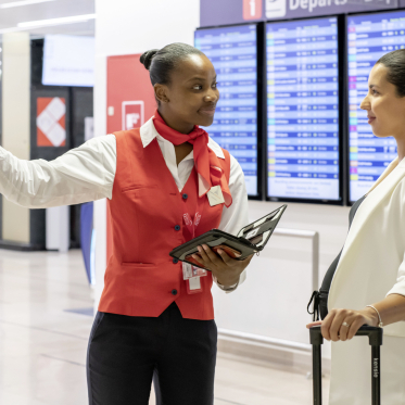 Une salarié de GSF renseigne une touriste dans un aéroport. 